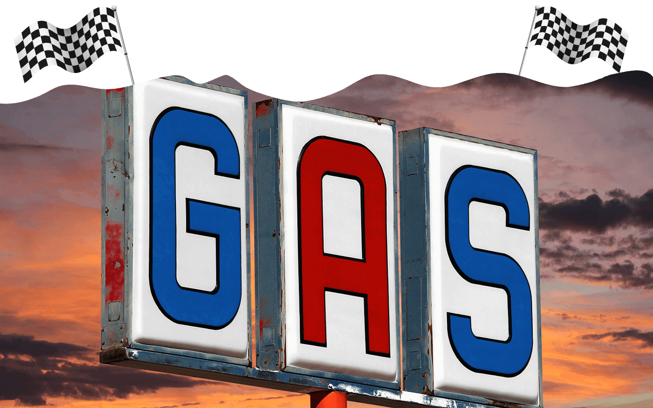 Gas sign with sunset in the background and checkered flags